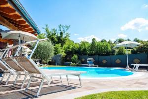 una silla y una sombrilla junto a la piscina en Sweet Life Villas, en Peschiera del Garda