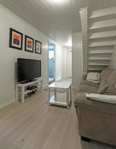 a living room with a couch and a television at Naturnær leilighet med 1 soverom in Sandnes