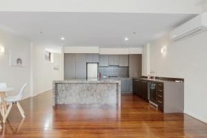 een keuken met houten vloeren en witte muren bij 2 bedroom apartment in the heart of the city! in Bendigo