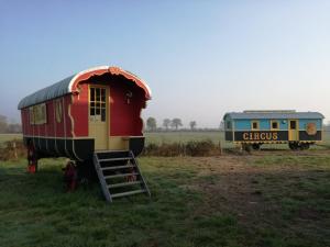 a small house and a train car in a field at La Roulotte Bohème des Grillots in Beaulon
