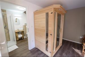 um quarto com um chuveiro de madeira num quarto em Bi d'Grosseltere Gîtes de charme em Kirrwiller