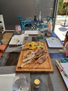 una mesa con una tabla de cortar con pescado. en VILLA RASOA chambre miroir, en Cap d'Agde