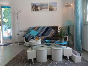 ein Wohnzimmer mit einem Sofa und einem Tisch in der Unterkunft Les Hauts d'Eyragues gîte Aigue Marine Meublé classé 4 étoiles in Eyragues