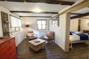 ein Schlafzimmer mit einem Bett, einem Stuhl und einem Tisch in der Unterkunft Bi d'Grosseltere Gîtes de charme in Kirrwiller