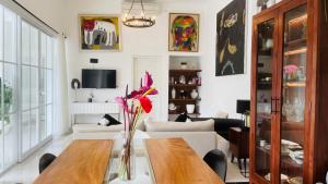 un salon avec une table avec un vase de fleurs dans l'établissement Keyla Canggu Villa, à Canggu