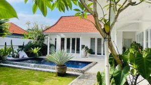 une villa avec une piscine dans un jardin dans l'établissement Keyla Canggu Villa, à Canggu