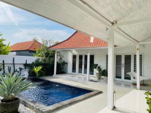 een patio met een zwembad en een huis bij Keyla Canggu Villa in Canggu