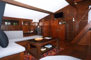 a living room with a couch and a table at The Hidden Escapes Manggis- Stunning Tiny Home set on a Lake with Mountain View, Private Sauna, Pool, Bicycles, BBQ & Butler! in Padangbai