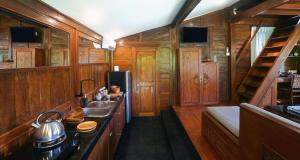 a kitchen with a stove and a sink in a train at The Hidden Escapes Manggis- Stunning Tiny Home set on a Lake with Mountain View, Private Sauna, Pool, Bicycles, BBQ & Butler! in Padangbai