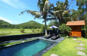 a pool in the backyard of a villa at The Hidden Escapes Manggis- Stunning Tiny Home set on a Lake with Mountain View, Private Sauna, Pool, Bicycles, BBQ & Butler! in Padangbai