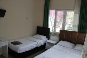1 dormitorio con 2 camas y ventana en Limon Pansiyon, en Edirne