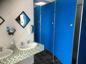 a bathroom with two sinks and a blue shower at African Soul Surfer in Muizenberg