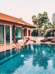 2 personnes jouant dans la piscine d'une maison dans l'établissement Content Villa Chiangmai, à Chiang Mai