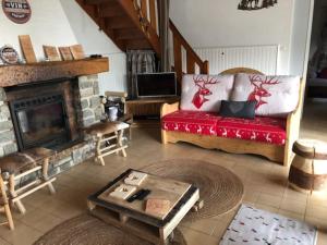sala de estar con sofá y chimenea en LE CHALET de la goutte en Saint-Appolinaire