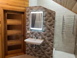 bagno con lavandino e specchio di Rodynne Gnizdo a Počaïv