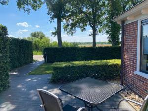 una mesa y sillas sentadas en un patio de ladrillo en Kindvriendelijk appartement de Hooge Stukken onder de rook van Groningen, en Eelde-Paterswolde