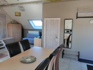 une salle à manger avec une table et des chaises ainsi qu'une chambre dans l'établissement Gîte Ferme d'hurtaux, à Froidchapelle