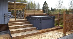 a deck with a hot tub and a gazebo at Kuusiston majatalo 