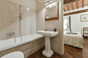 a bathroom with a sink and a bath tub and a sink at Buonarroti big apartment with terrace in Oltrarno in Florence