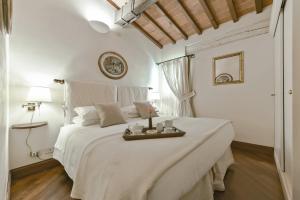 a bedroom with a large white bed with a table on it at Buonarroti big apartment with terrace in Oltrarno in Florence
