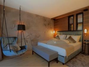 a bedroom with a bed and a chair at Boutique Hotel die Mittagspitze Superior in Damuls