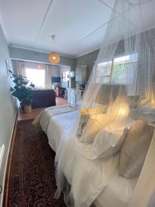 una camera da letto con un grande letto e una zanzariera di La Mer Seafront Selfcatering Accommodation Kleinmond a Kleinmond