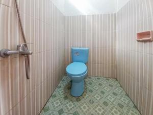 a bathroom with a blue toilet in a stall at Villa Kampoeng City Pacet Mitra RedDoorz in Mojokerto +21 photos
