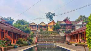 a row of houses with a pool in front of them at Villa Kampoeng City Pacet Mitra RedDoorz in Mojokerto