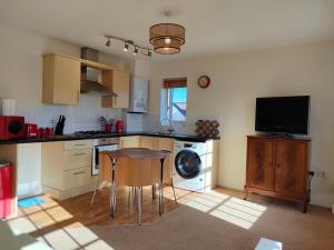 a kitchen with a table and a dishwasher at Central Taunton 2-bedroom apartment, great location! in Taunton