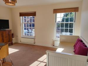 a living room with a couch and two windows at Central Taunton 2-bedroom apartment, great location! in Taunton