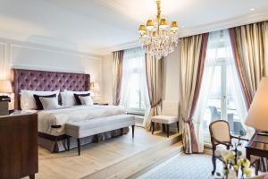 Un dormitorio con una cama grande y una lámpara de araña. en Fairmont Hotel Vier Jahreszeiten, Hotel des Jahres 2023 & 2024- Die 101 Besten, en Hamburgo