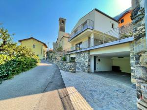 una casa con garaje y un edificio con una torre de reloj en Relax, silence, romantic, amazing view en Laglio