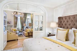 um quarto com uma cama grande e uma sala de estar em Fairmont Hotel Vier Jahreszeiten, Hotel des Jahres 2023 & 2024- Die 101 Besten em Hamburgo