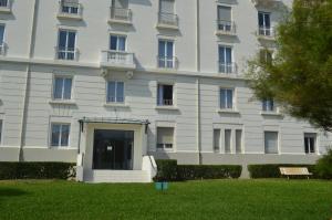a large white building with a lawn in front of it at Studios Régina (Mer-Golf) in Biarritz