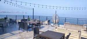 un restaurante con mesas y sillas en un balcón con vistas al océano en Guest house Garden Beach, en Batumi