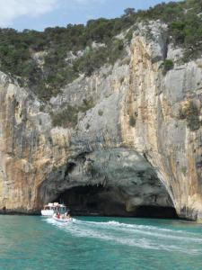 a boat in front of a cave in the water at Mare e relax in Quartucciu