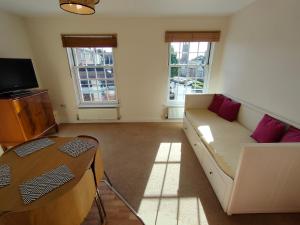 a living room with a couch and a television at Central Taunton 2-bedroom apartment, great location! in Taunton