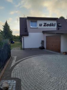 uma entrada em frente a uma casa com garagem em Apartamenty rodzinne U Zośki em Łukęcin