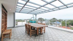 a dining room with a table and chairs on a balcony at RedDoorz at DBuilders Rooms Lower Bicutan in Manila