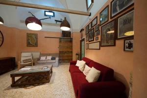 een woonkamer met een rode bank en een salontafel bij B&B Palazzo la Traja in Gagliano del Capo