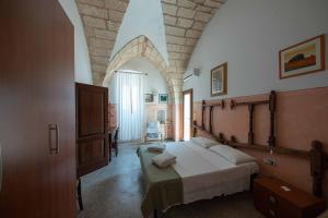 een slaapkamer met een groot bed in een kamer bij B&B Palazzo la Traja in Gagliano del Capo