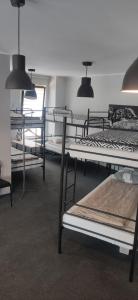 a room with several bunk beds and lights at Hostel Sunrise przy DW. Zachodnim in Warsaw