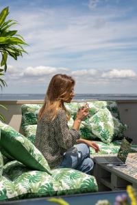 a woman sitting on a couch with a glass of wine at Hotel DAH - Dom Afonso Henriques in Lisbon
