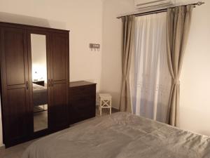 a bedroom with a bed and a dresser and a mirror at Stilvi Milos in Plaka Milou