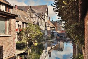 a river in the middle of a city with buildings at Appartement Centre ville Louviers in Louviers