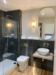 a bathroom with a toilet and a sink and a mirror at Hygge at Vallum in Newcastle upon Tyne