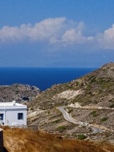 a small white building on a hill with a winding road at Stilvi Milos in Plaka Milou