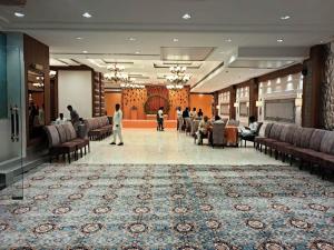 a lobby of a hotel with people sitting in chairs at Hotel Sakura by Maps in Gurgaon +37 photos