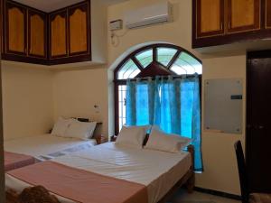 a bedroom with two beds and a large window at Bluemoon Bungalow in Pondicherry +44 photos