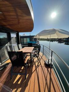 una terraza de madera con mesa y sillas en un barco en Hausboot Vroni am Bärwaldersee en Klitten